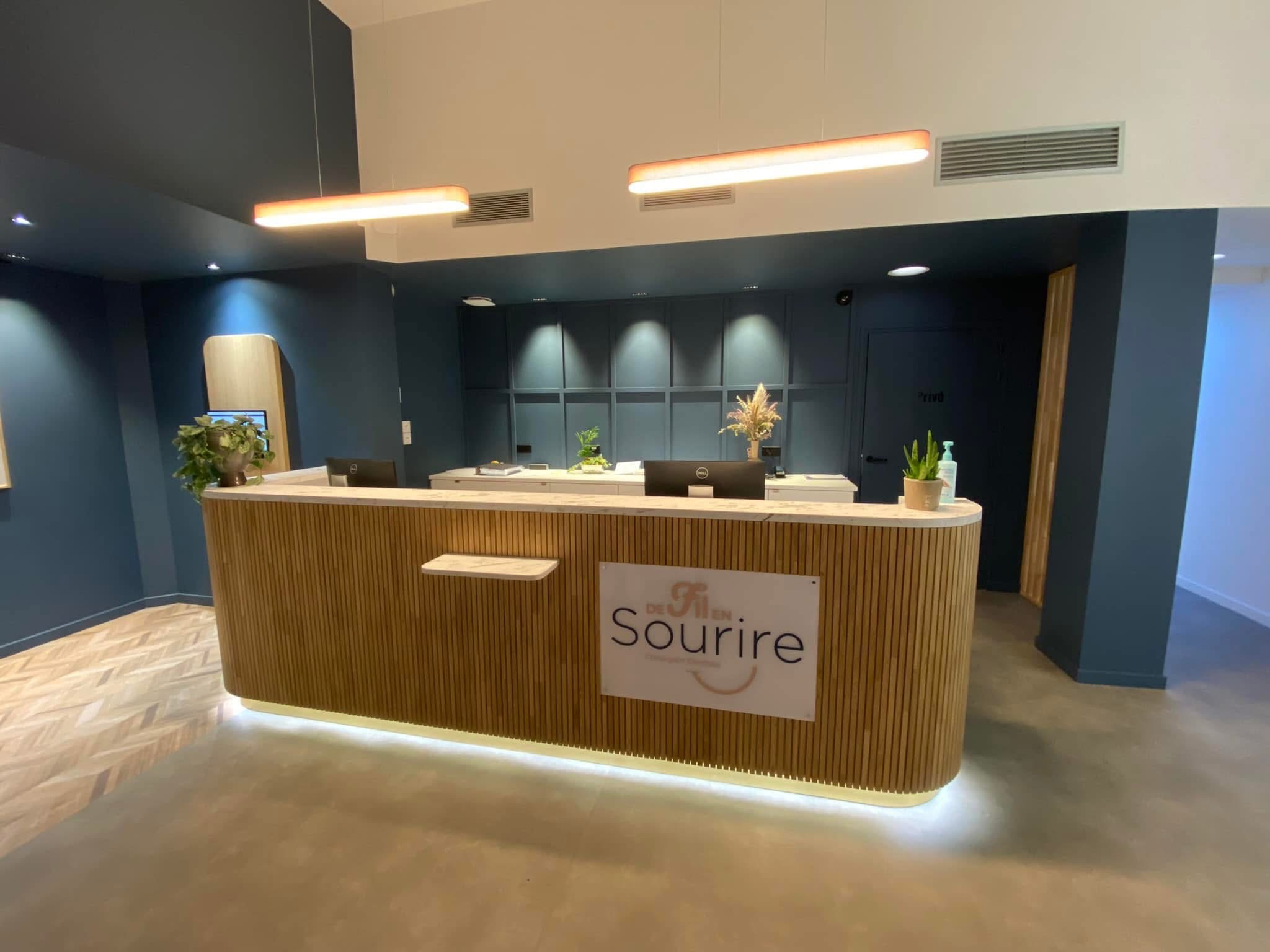 Banque d’accueil en bois à lattes verticales et éclairage en pied