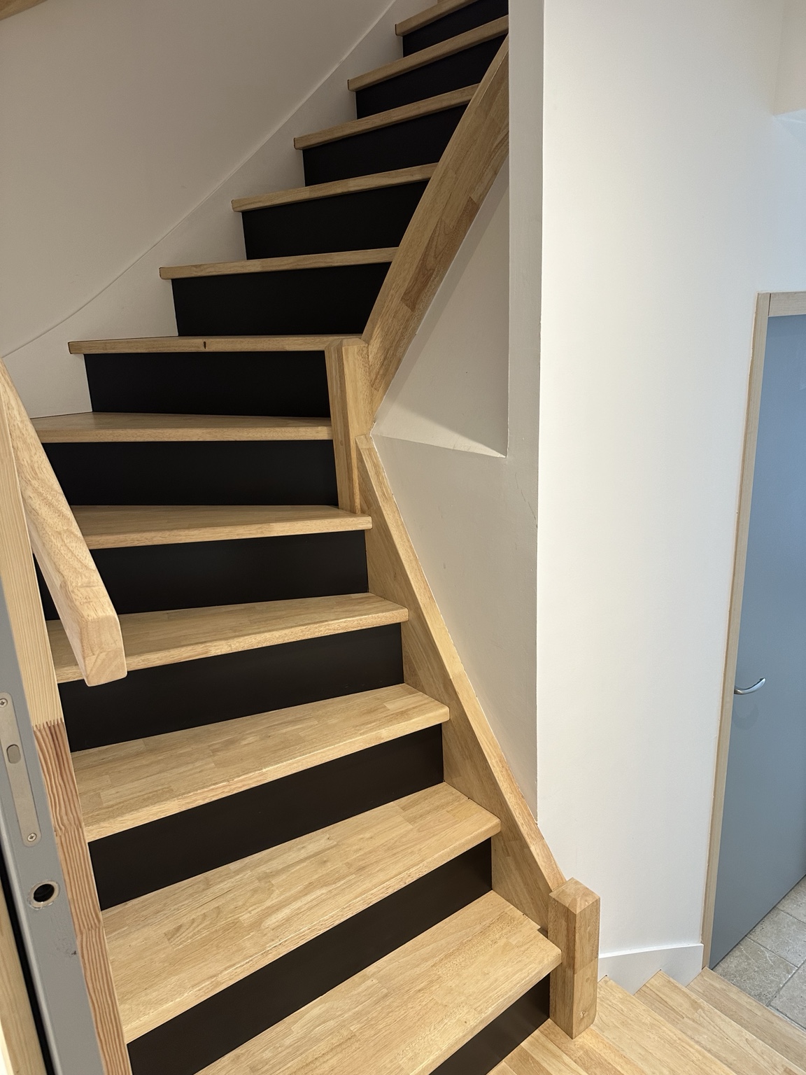 Escalier tournant en bois avec contremarches noires