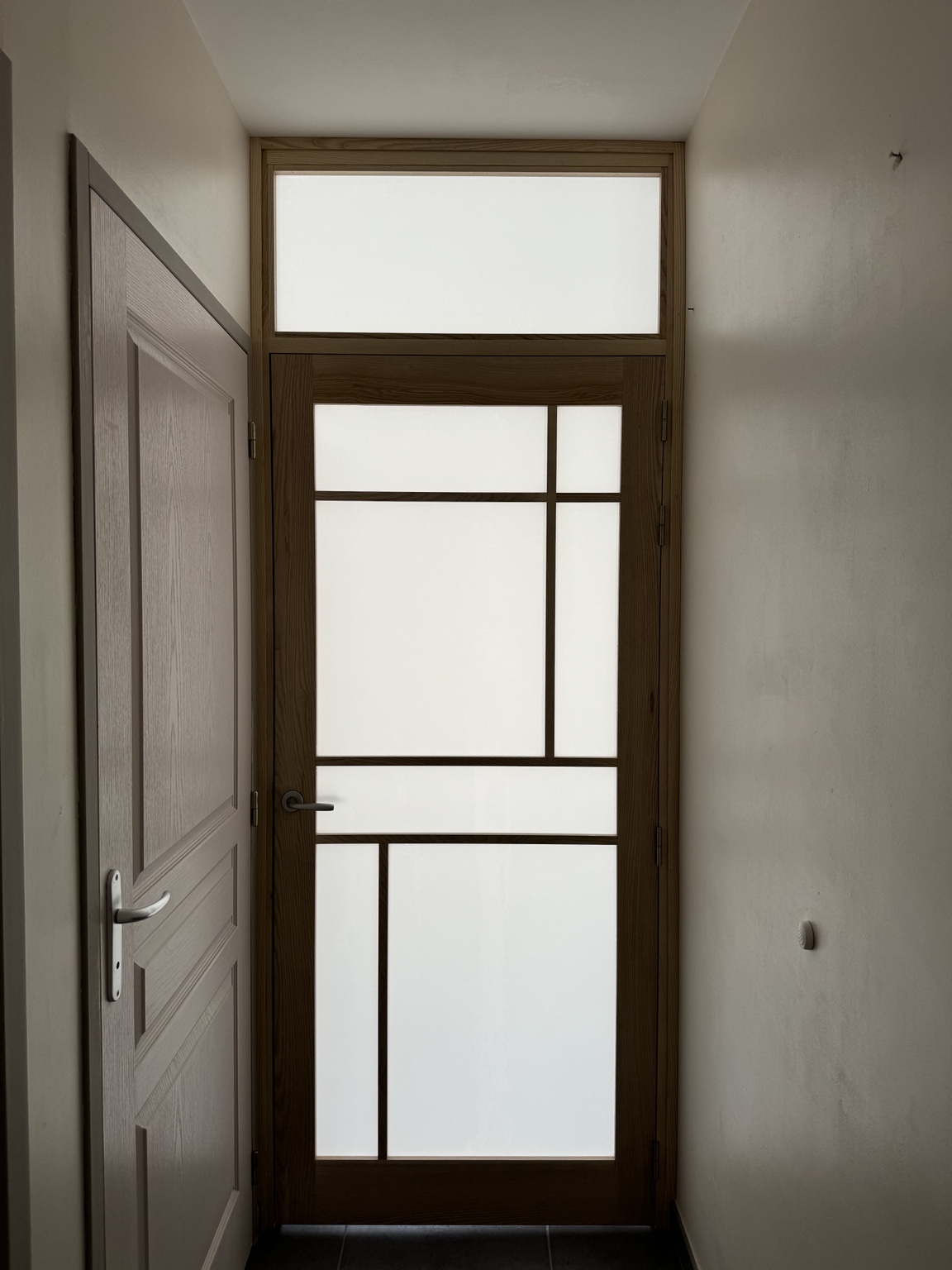 Porte intérieure en bois avec vitrage dépoli et imposte