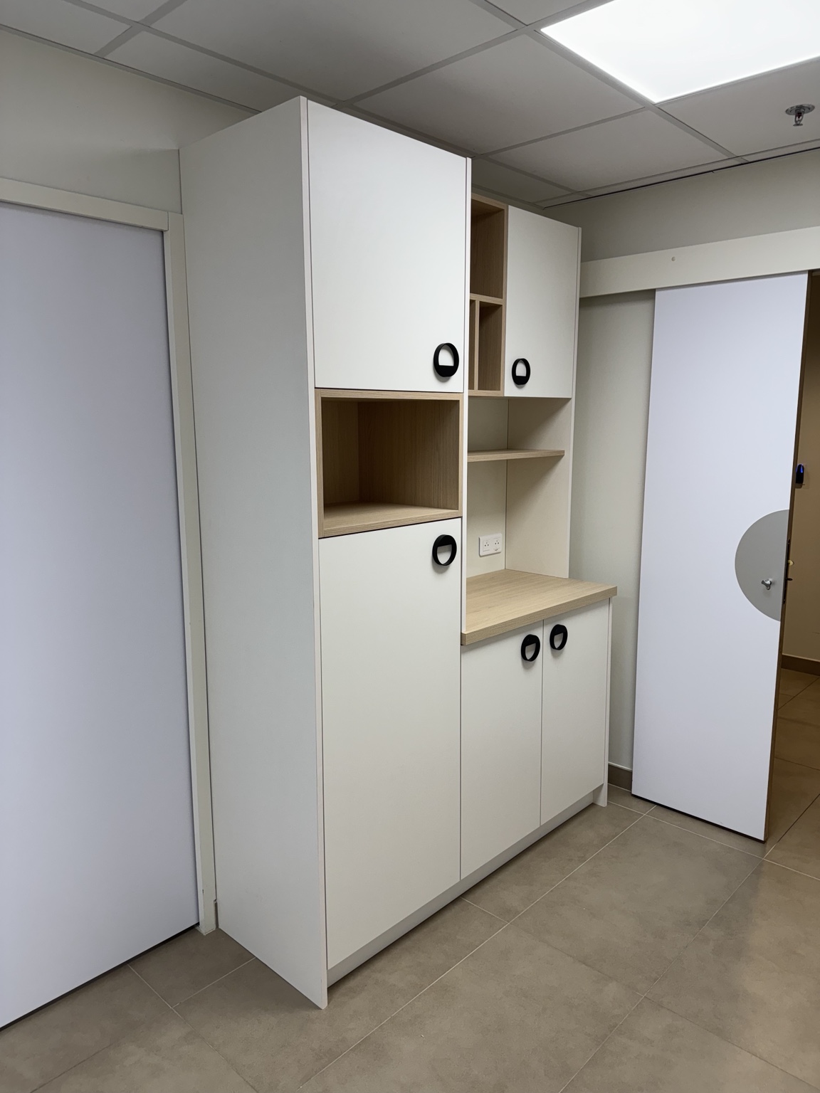 Tisanerie blanche avec niches en bois et plan de travail